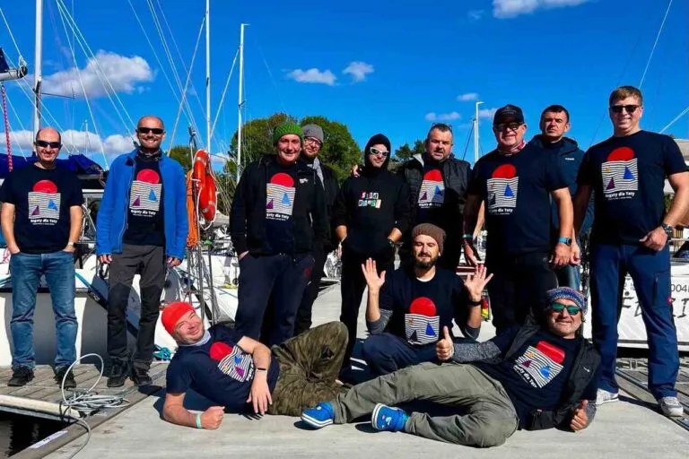 Załogi regat na pomoście w firmowych strojach-port Sztynort.