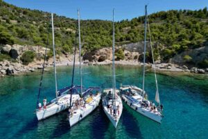 Zatoka w Grecji i flotylla jachtów Fun&Flow zakotwiczona obok siebie na turkusowej wodzie