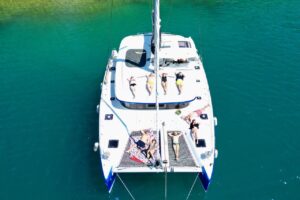 Rejs katamaranem w Chorwacji – dorośli odpoczywający na siatkach katamaranu na turkusowej wodzie