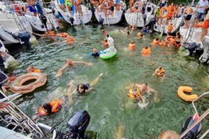 Rodziny kąpiące się w jeziorze podczas mazurskiego rejsu.