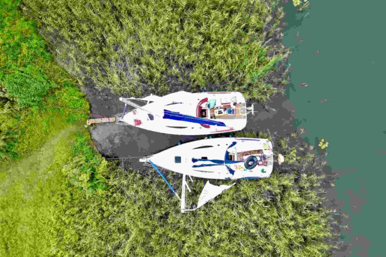 Rejs po Mazurach – dwa jachty zacumowane przy dzikiej zatoce wśród trzcin