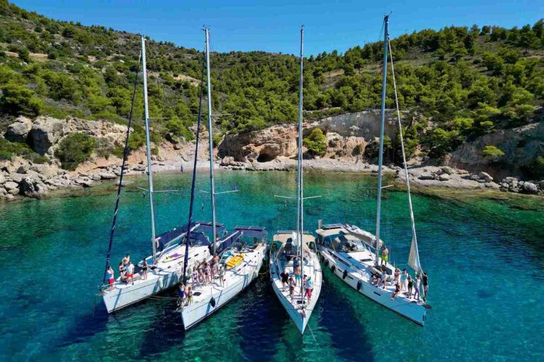 Flotylla jachtów w greckiej zatoce podczas rejsu rodzinnego.