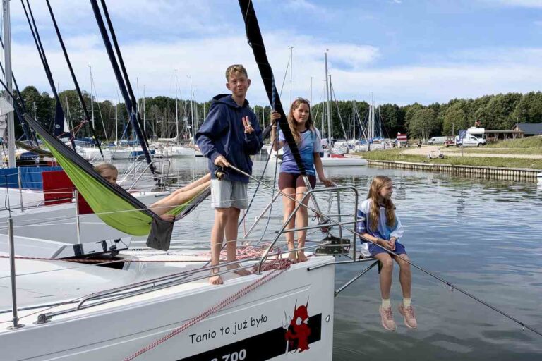 Dzieci i nastolatki odpoczywające na jachcie podczas rejsu Tata na Mazury